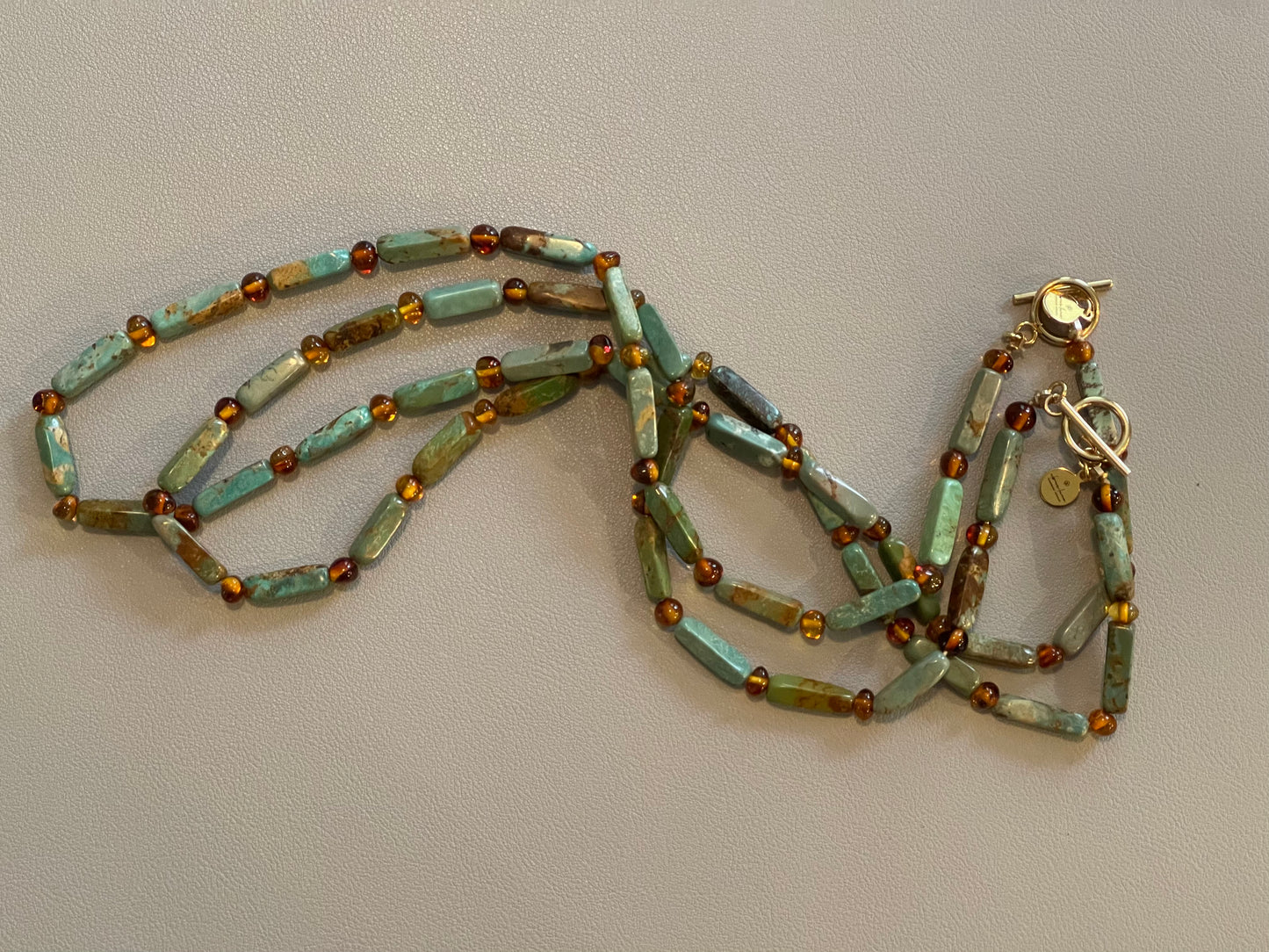 Verdant Glow Necklace: Turquoise and Baltic Amber stone with gold toggle clasp