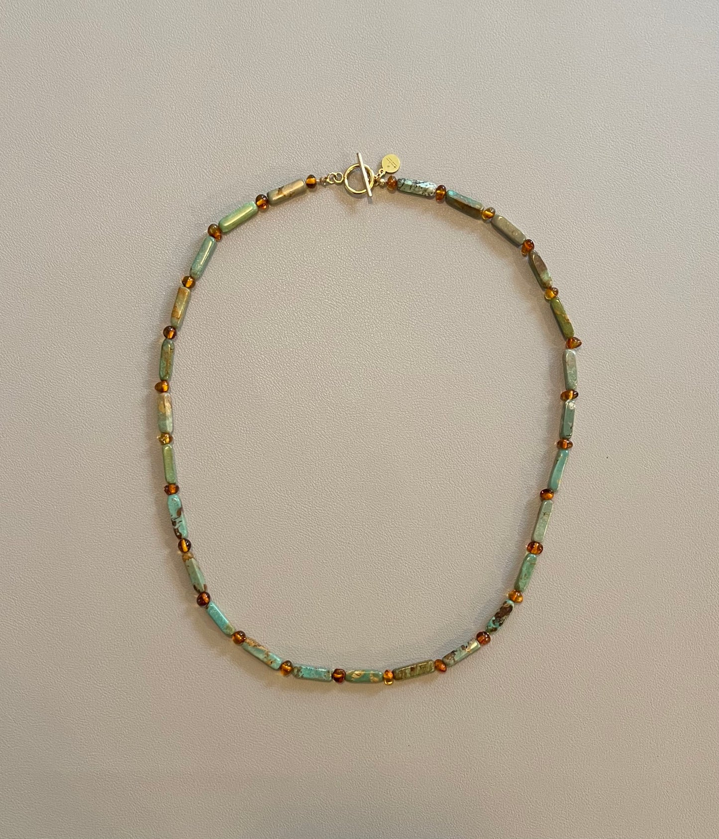 Verdant Glow Necklace: Turquoise and Baltic Amber stone with gold toggle clasp