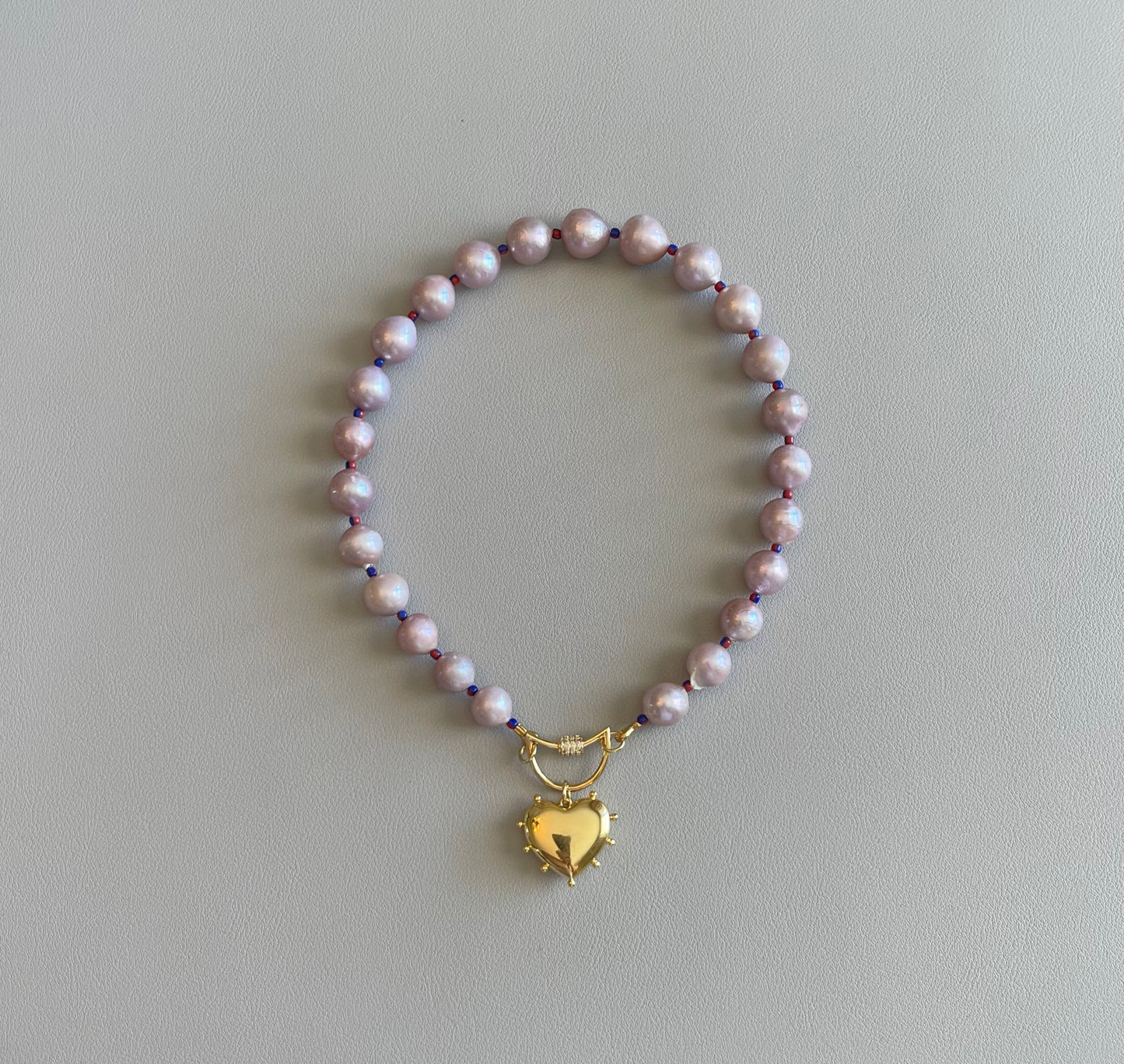The Yves Necklace: Lavender Edison Pearls w/glass spacers, a gold crescent clasp holding a heart pendant OOAK