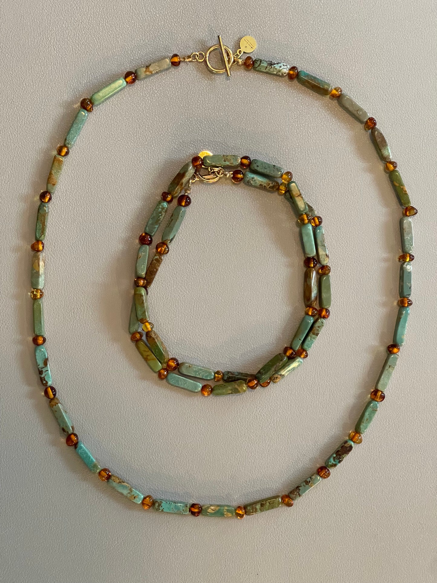 Verdant Glow Necklace: Turquoise and Baltic Amber stone with gold toggle clasp