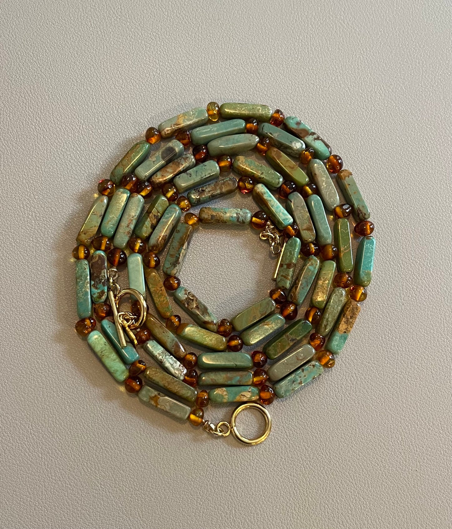 Verdant Glow Necklace: Turquoise and Baltic Amber stone with gold toggle clasp