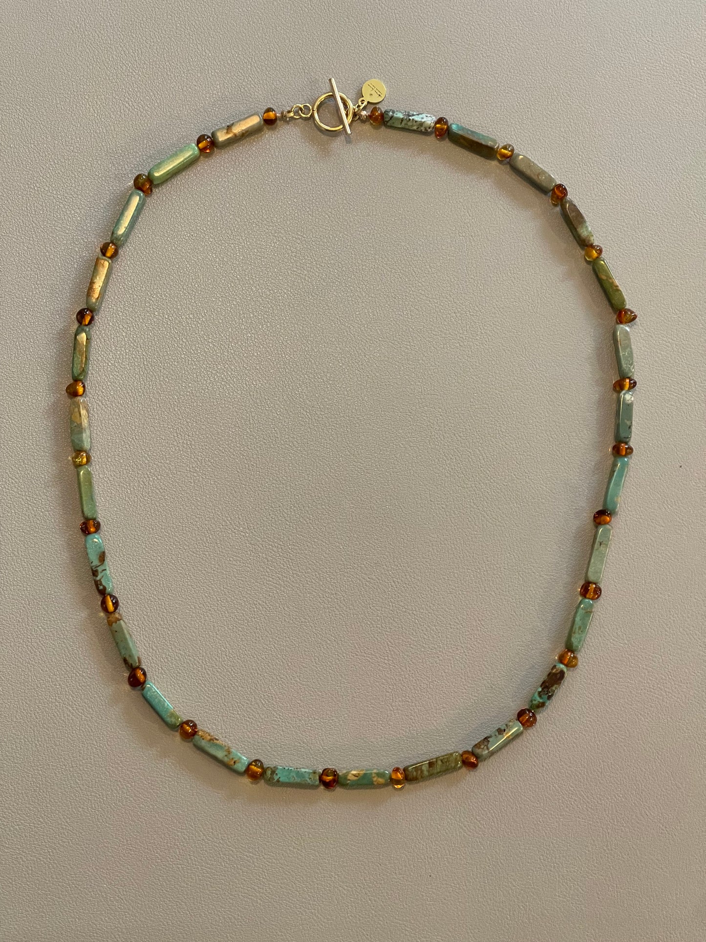 Verdant Glow Necklace: Turquoise and Baltic Amber stone with gold toggle clasp