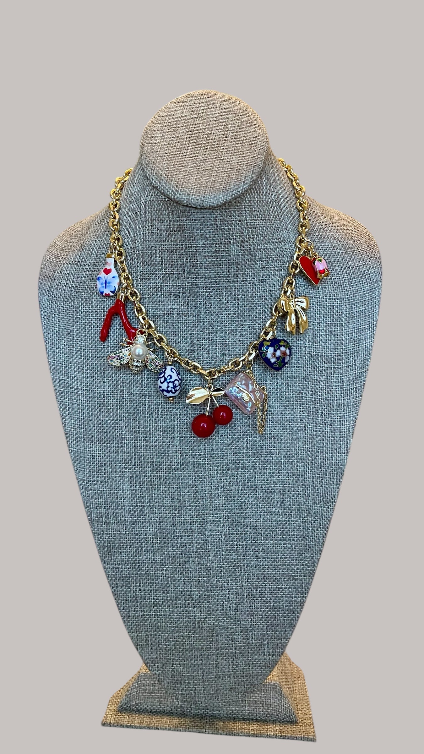 The Jackie Necklace: Tarnish resistant gold chain with various charms in a red pink & blue theme