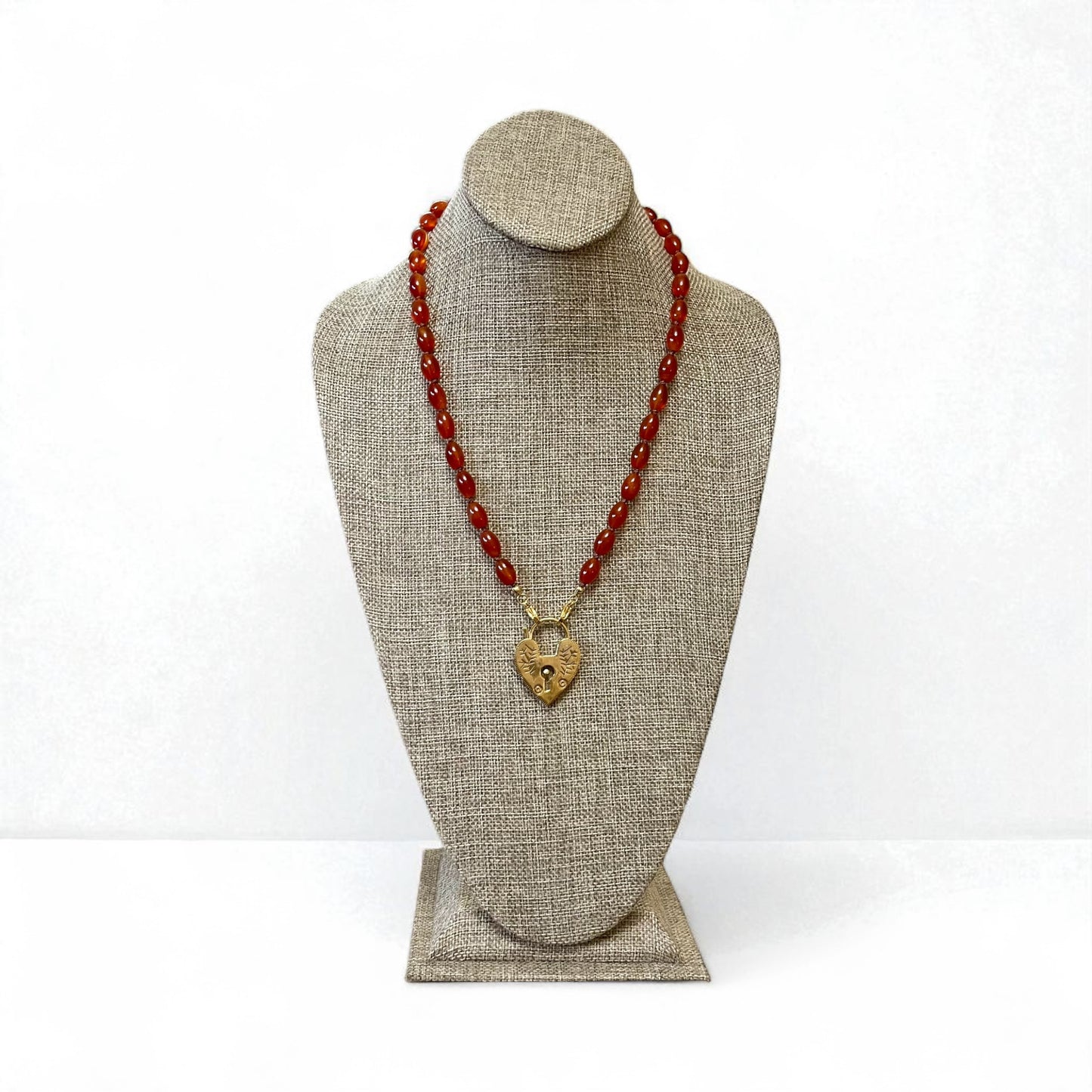 Carnelian Heartlock Necklace: Carnelian gemstone oval beads handknotted on warm brown silk GF heart pendant