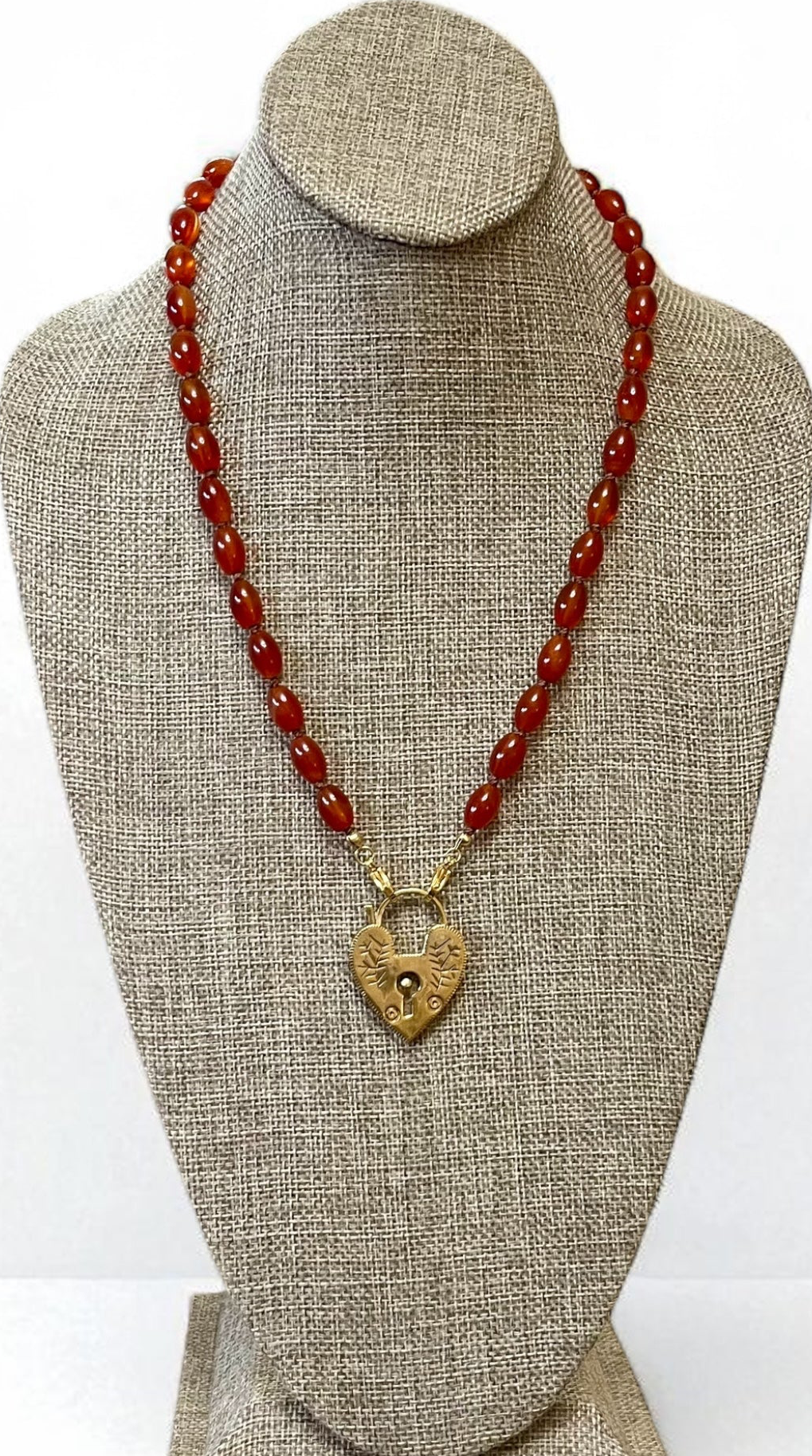 Carnelian Heartlock Necklace: Carnelian gemstone oval beads handknotted on warm brown silk GF heart pendant