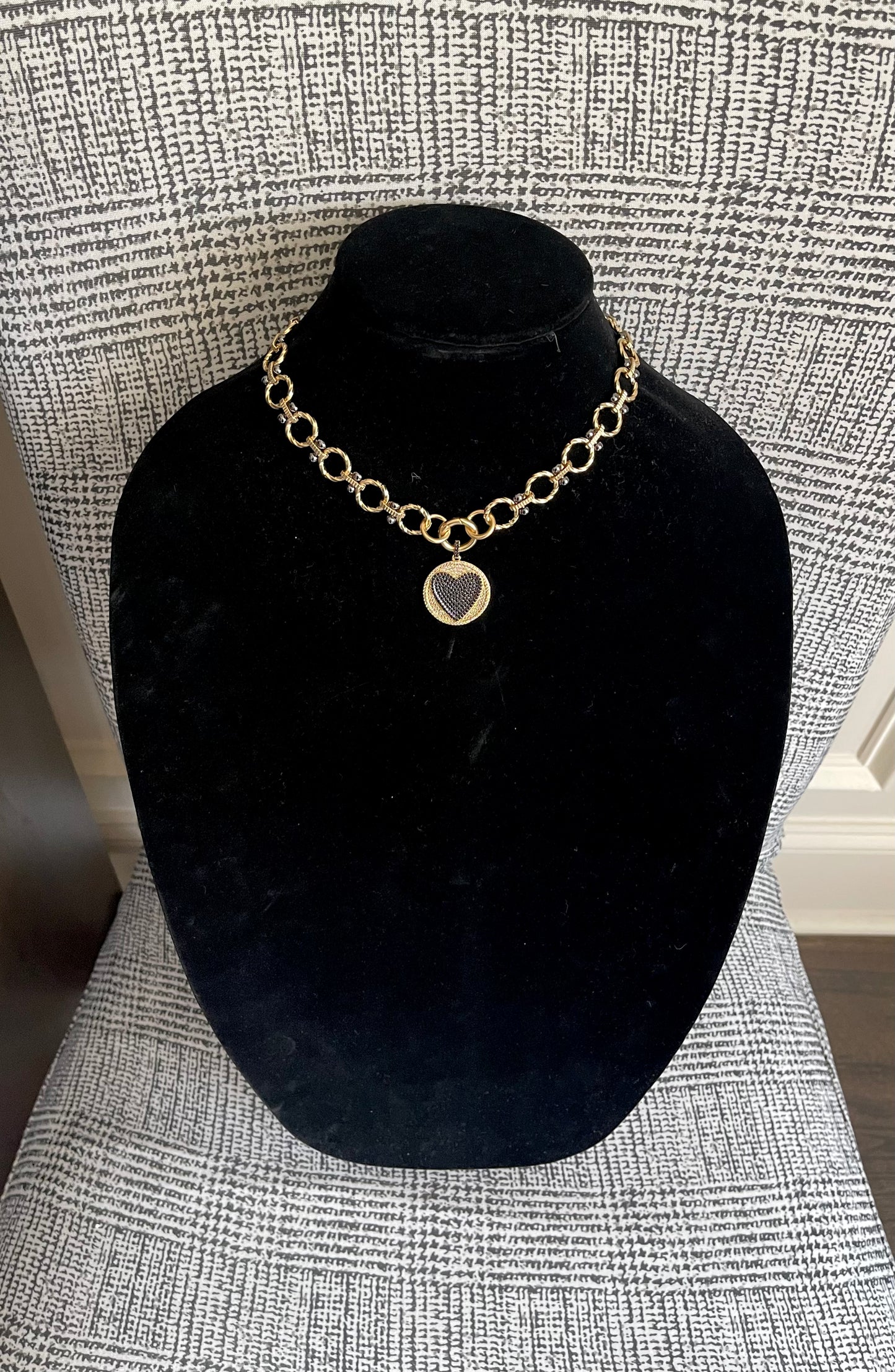 Heart On Your Sleeve Necklace: Brushed gold chain with gunmetal accents, a push gate circle clasp and pavé heart pendant