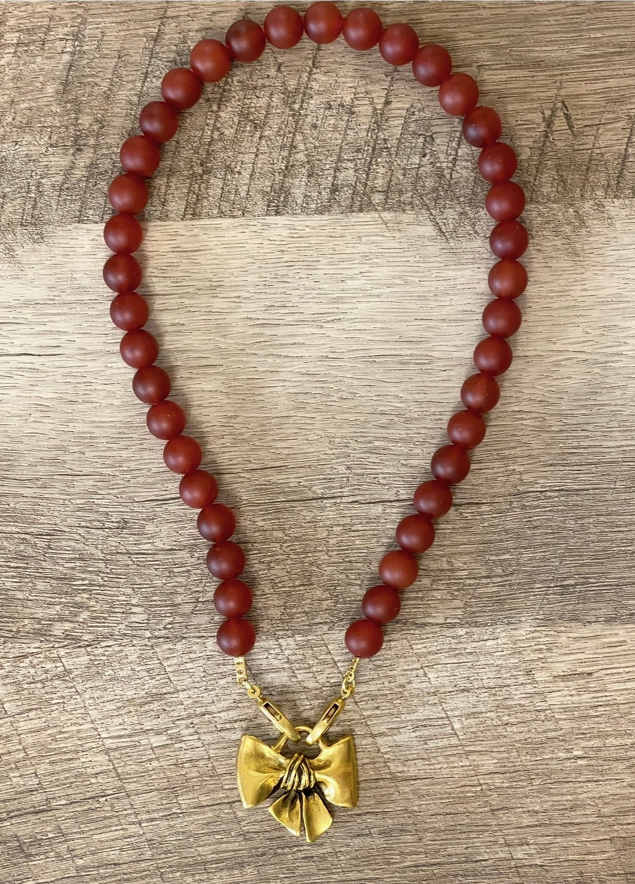 Matte Carnelian Bow Necklace: Matte Carnelian gemstone beads Antiqued gold bow pendant
