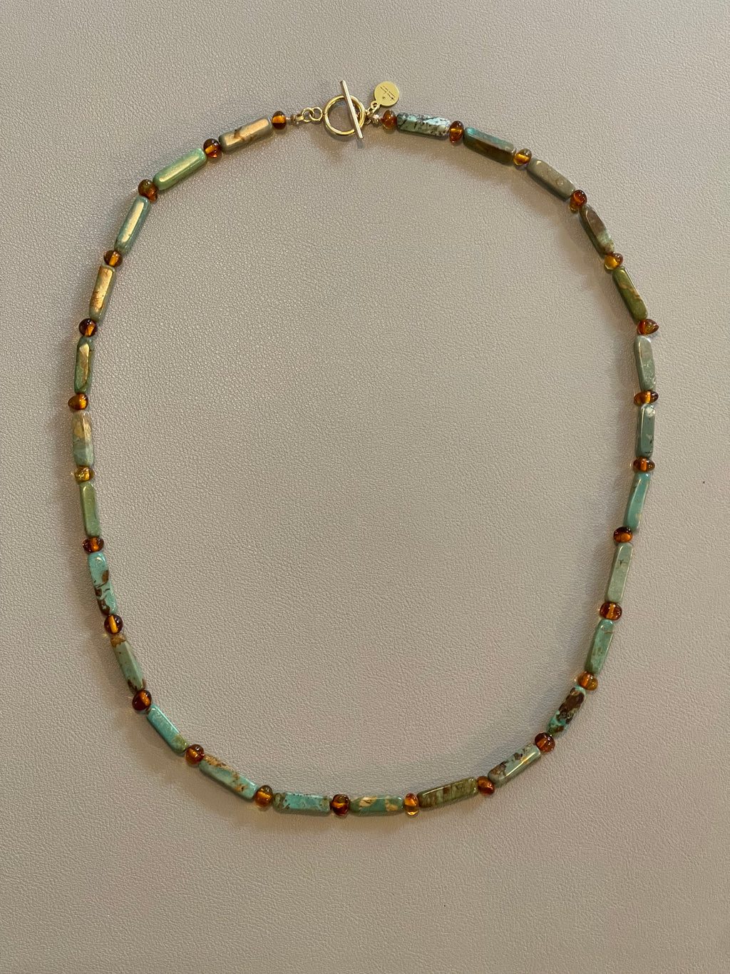 Verdant Glow Necklace: Turquoise and Baltic Amber stone with gold toggle clasp