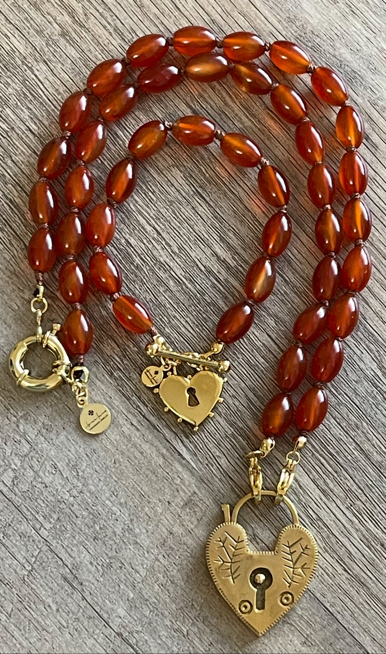 Carnelian Heartlock Necklace: Carnelian gemstone oval beads handknotted on warm brown silk GF heart pendant