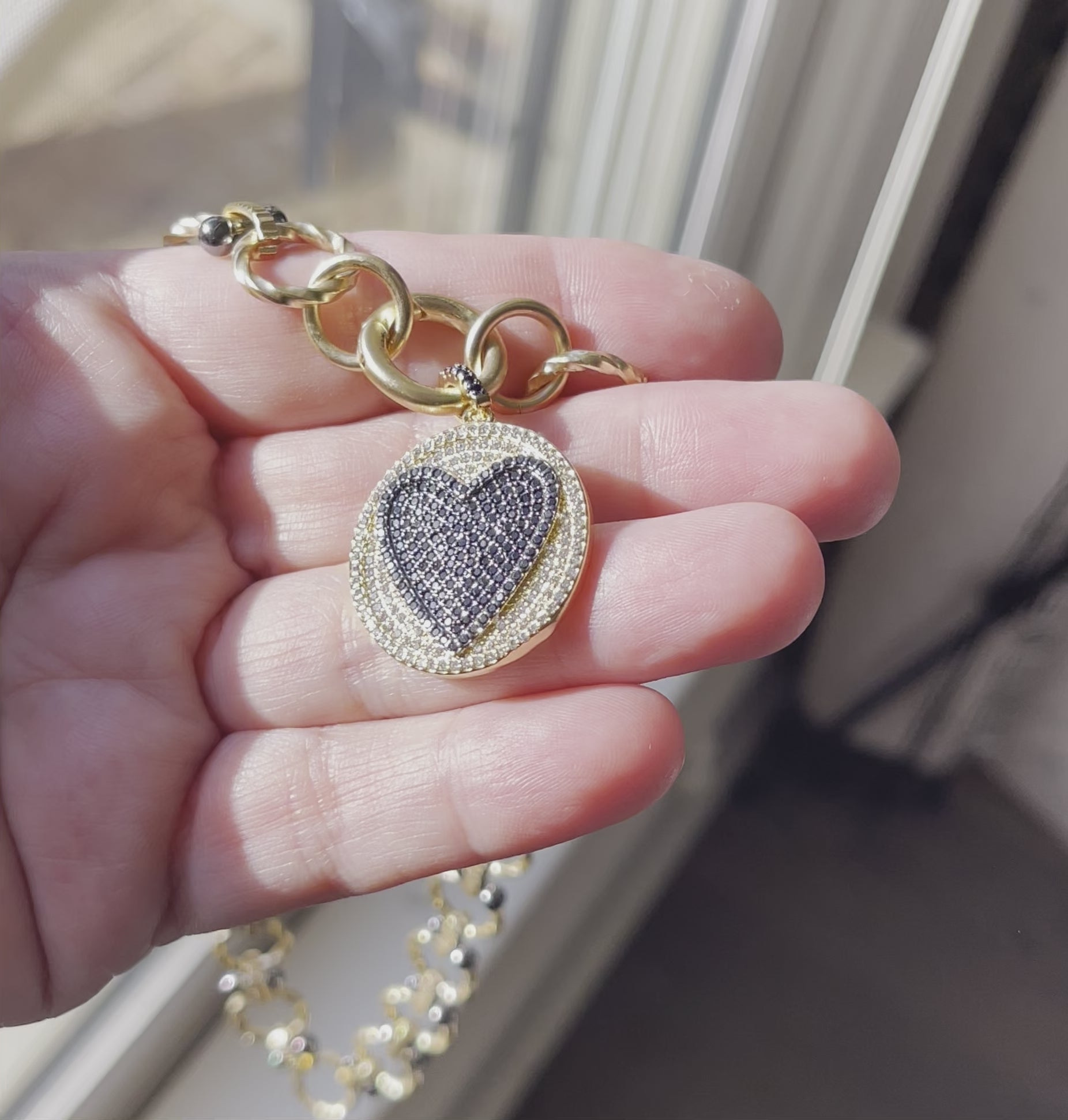 Heart On Your Sleeve Necklace: Brushed gold chain with gunmetal accents, a push gate circle clasp and pavé heart pendant